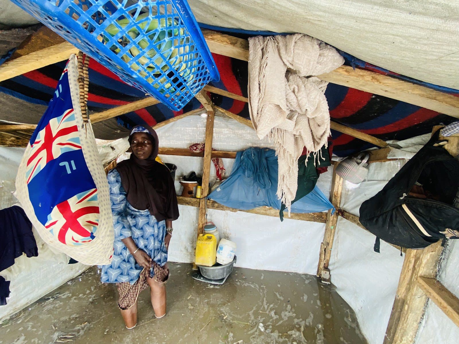 Hadiza Umar Ali stands in her flooded tent in a camp in Shuwari V camp.