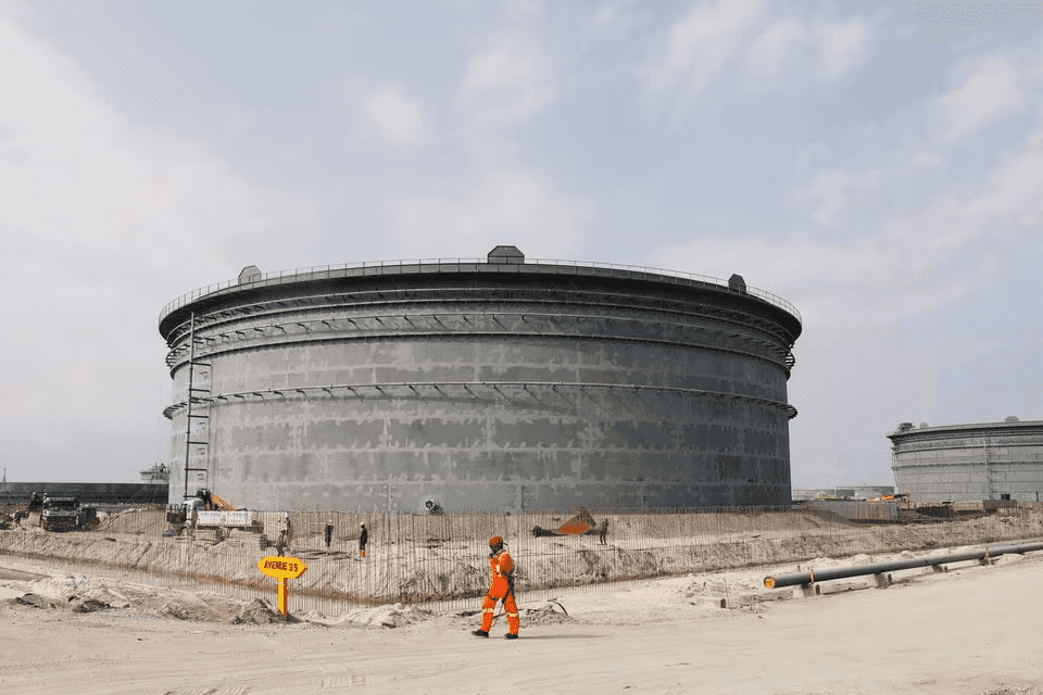 A worker walks past storage tanks at the Dangote oil refinery in Ibeju Lekki, Lagos, Aug. 7, 2019. Photo: Temilade Adelaja/Reuters.