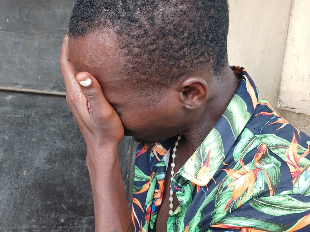 Person holding their head in their hand, showing signs of distress or deep thought.