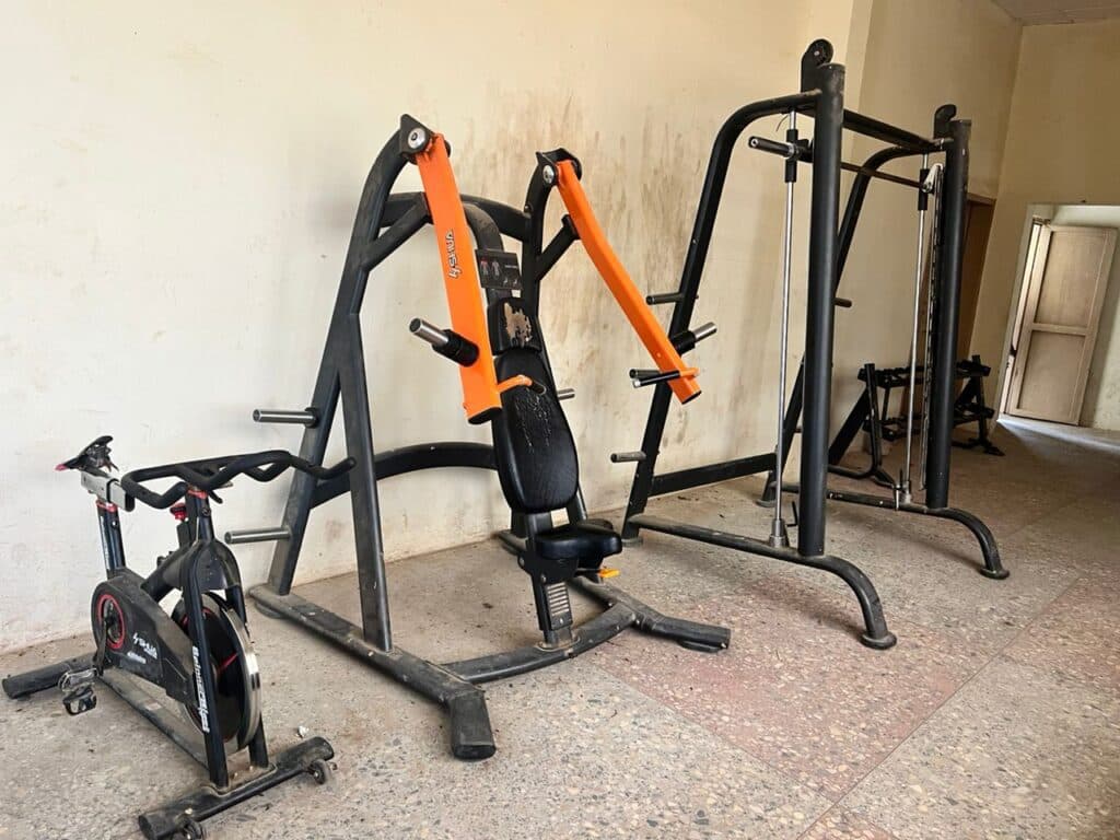 A home gym with an exercise bike, chest press machine, and pull-down machine.