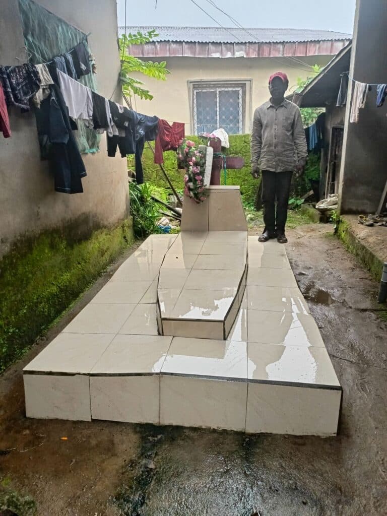 Person standing at the base of wet outdoor stairs with laundry hanging nearby.