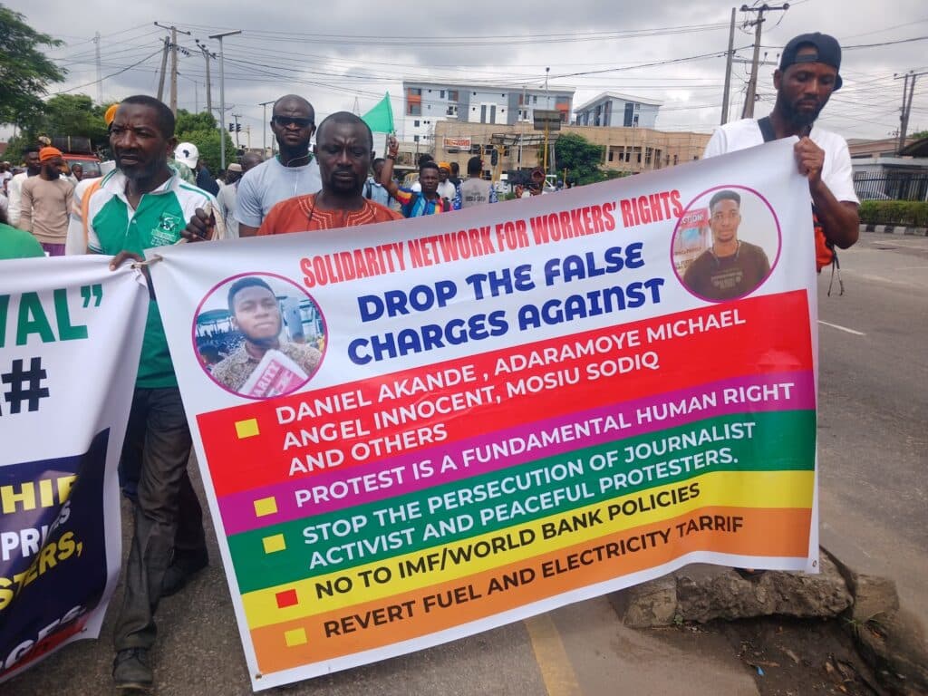 Group of individuals holding a protest banner calling for workers