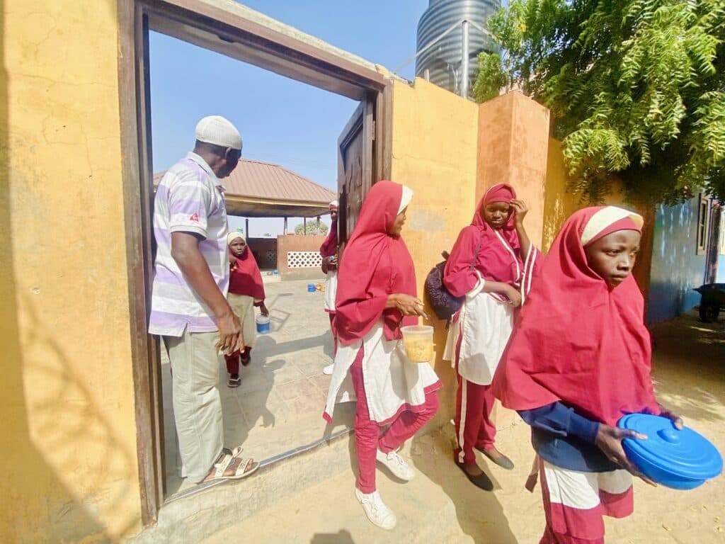 A group of girls standing in front of a door.