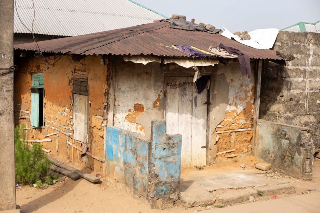 Dilapidated house with peeling paint and rusty corrugated roof.