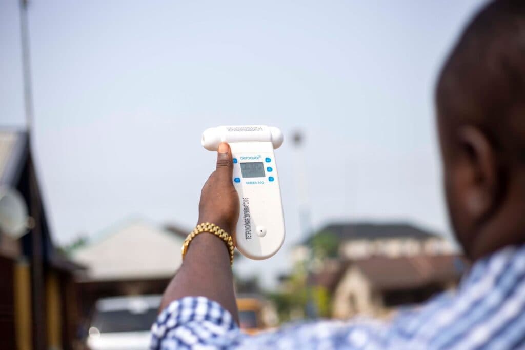 Person holding a handheld device towards the sky with display screen visible.