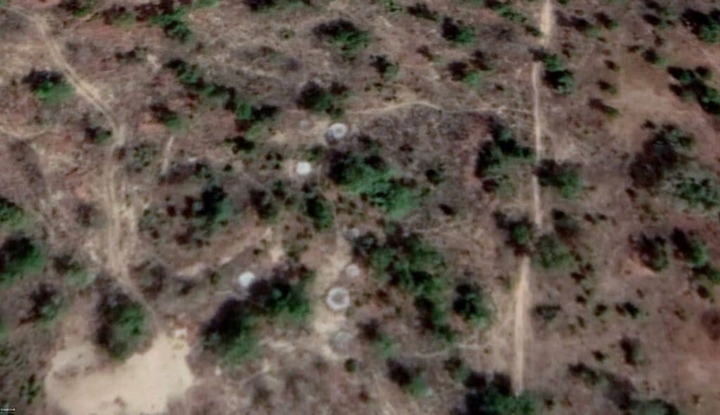 Aerial view of a dry landscape with sparse vegetation and dirt trails.