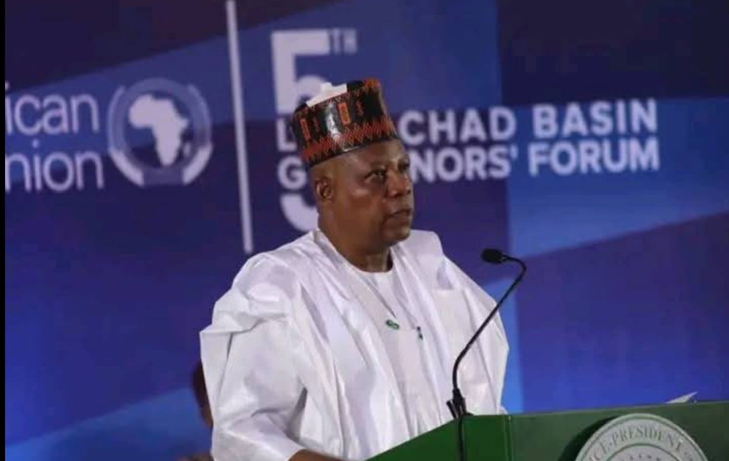 A speaker in traditional attire stands at a podium during the 5th Lake Chad Basin Governors' Forum.