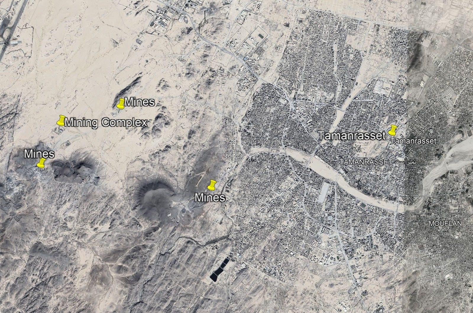 Satellite view of Tamanrasset, Algeria, showing labeled mines and a mining complex in the surrounding desert area.